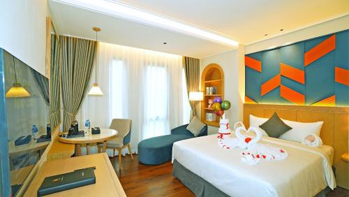 una camera d'albergo con letto e scrivania di SAIGON_AROMA_HOTEL a Hanoi