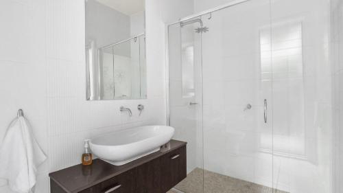 a white bathroom with a sink and a shower at Dashaz Dream - The Vintage in Pokolbin