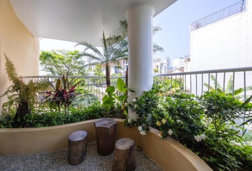 a balcony with plants and stools in a building at Saha Casa Boutique Hotel Da Nang in Da Nang