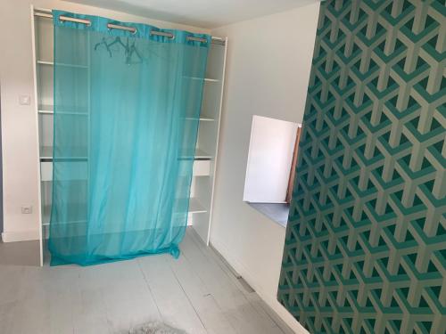 La salle de bains est pourvue d'une douche avec un rideau bleu. dans l'établissement Maison spacieuse et familiale, à Pexonne