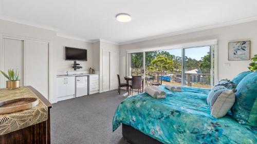 a bedroom with a large bed with a view at Cypress Point Lodge - The Vintage in Pokolbin