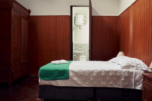 Residencial Roma Bed & Breakfast في ليما: غرفة نوم بسرير كبير ومرآة