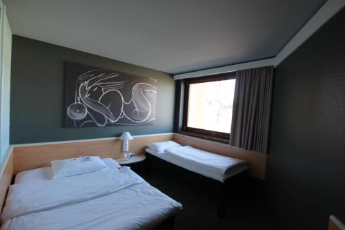 a bedroom with two twin beds and a window at Ibis Wien Mariahilf in Vienna