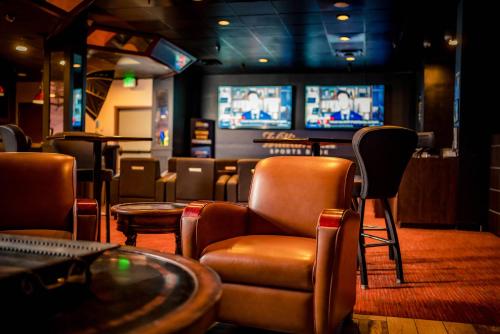 a bar with chairs and tables and televisions at The Federal Hotel Downtown Carson City, an Ascend Collection Hotel in Carson City
