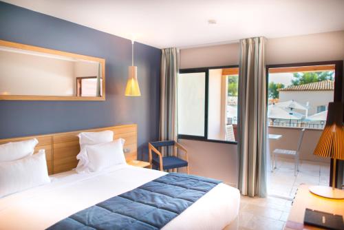 a hotel room with a bed and a balcony at Le Fregate Provence in Bandol