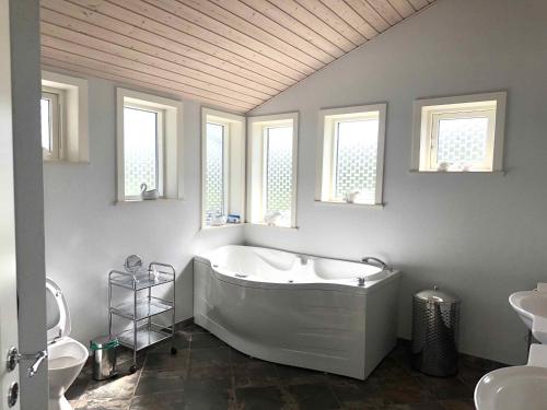 y baño con bañera, lavabo y aseo. en Holiday Home With Exceptional Sea View, en Børkop