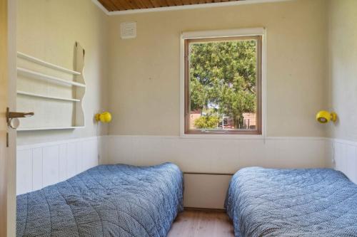 dwa łóżka w pokoju z oknem w obiekcie Summer Cottage Idyll At Natures Pearl, w mieście Stubbekøbing