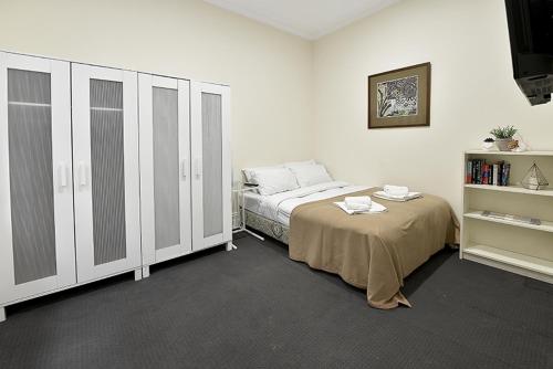 een slaapkamer met een bed en een boekenplank bij 51CR3 - Lovely One Bedroom Apt Next to RMIT! AC, 50incTV in Melbourne