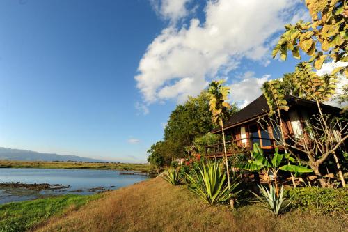 a house on the banks of a river at Villa Inle Boutique Resort in Nyaung Shwe