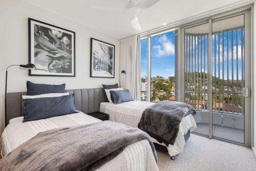- une chambre avec 2 lits et une grande fenêtre dans l'établissement Miles on Kirra Unit 907, à Gold Coast