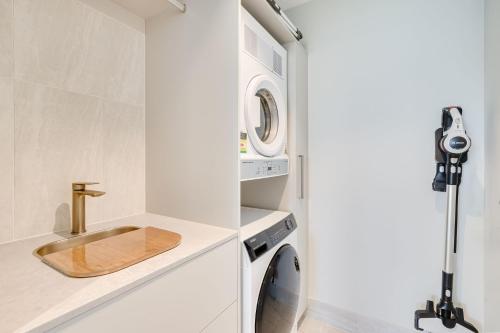 La salle de bains est pourvue d'un lavabo et d'un lave-linge. dans l'établissement Miles on Kirra Unit 907, à Gold Coast