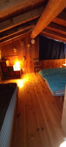 une chambre avec un lit et un parquet dans l'établissement Tony gîte chelou, à Lanslevillard