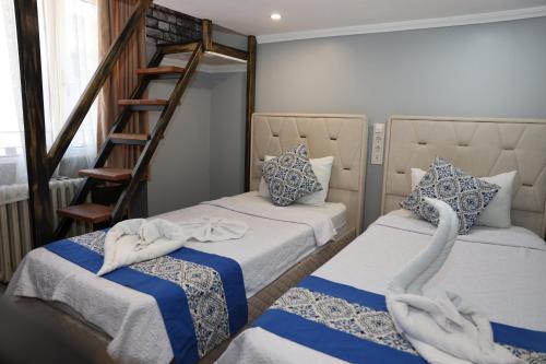 a room with two beds and a staircase with swan towels at The Time Hotel Adana in Seyhan