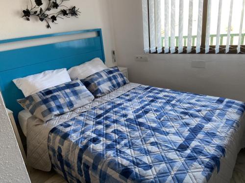 a bedroom with a blue and white bed with pillows at Appartement Empuriabrava in Empuriabrava