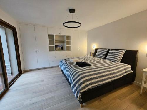 - une chambre avec un grand lit et une couverture rayée dans l'établissement La Maison du Grand Sapin, à Saint-Gatien-des-Bois