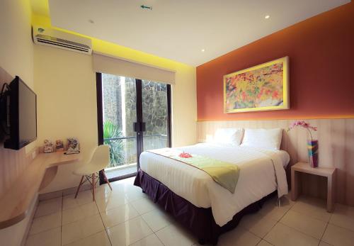 1 dormitorio con 1 cama, TV y ventana en D'Bamboo Suites, en Yakarta