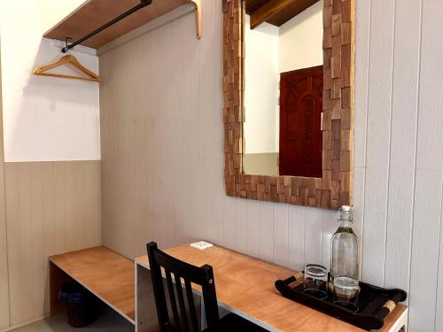 a dining room table with a bottle and a mirror at Canopus Retreat Thulusdhoo in Thulusdhoo