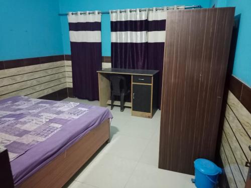 a room with a bed and a desk and curtains at Accueillir PG in Jhājra