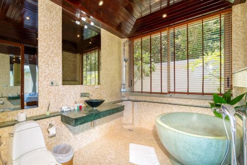 a bathroom with a tub and a sink and a toilet at Rockstarvillas - Villa Madonna in Bophut 