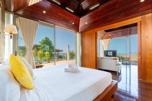 a bedroom with a large white bed with a large window at Rockstarvillas - Villa Madonna in Bophut 