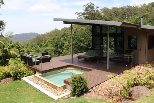 a house with a deck and a swimming pool at Crystal Creek Rainforest Retreat in Crystal Creek