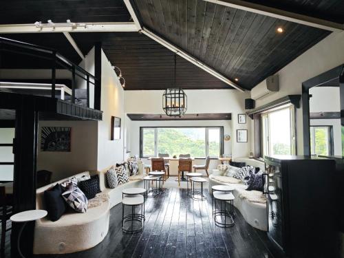 a living room with couches and a table and chairs at 金石新月光 Gold Stone Crescent Moon Light in Jiufen