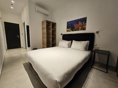 a bedroom with a large white bed with a table at Sun Sea Center in Eilat
