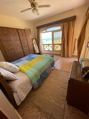 a bedroom with a bed and a window with a view at فيلا دوبلكس مع حديقة وشواية in El Tor