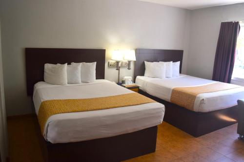 a hotel room with two beds and a window at SF Central Hotel in San Francisco