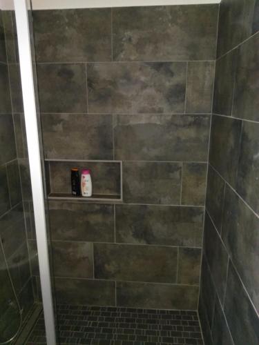een badkamer met een douche en een stenen muur bij Aldo haus in Siegen