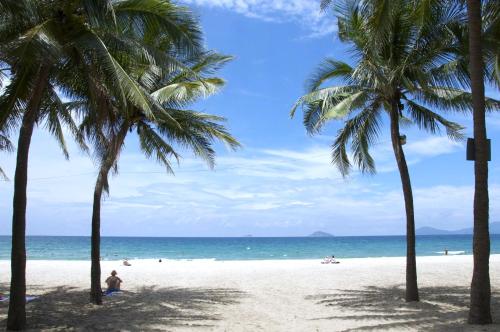 a group of palm trees on a beach with the ocean at Wyndham Garden Hoi An Cua Dai Beach in Hoi An