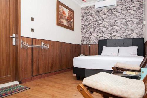 - une chambre avec un lit et une chaise dans l'établissement Apartement island, à Jakarta