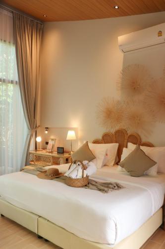 a bedroom with two beds with a large white bedspread at บ้านไร่มีสุข Baanrai Meesuk in Surat Thani
