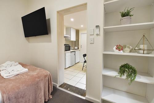 Cette petite chambre comprend un lit et une cuisine. dans l'établissement Lovely One Bedroom Apt Next to RMIT! AC, 50inc TV, à Melbourne