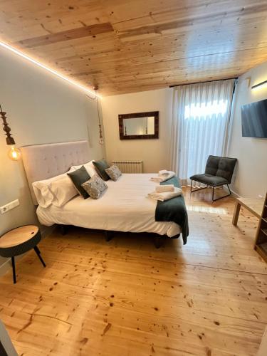 - une chambre avec un grand lit et un plafond en bois dans l'établissement Can Bernades, à Puigcerdà