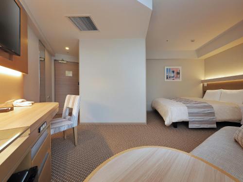 a hotel room with two beds and a television at Keio Presso Inn Otemachi in Tokyo