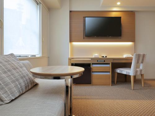 a hotel room with a desk and a tv at Keio Presso Inn Otemachi in Tokyo
