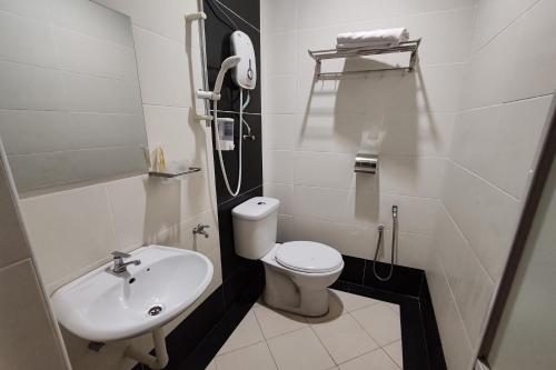 a small bathroom with a toilet and a sink at Hotel Sri Puchong Sdn Bhd in Puchong