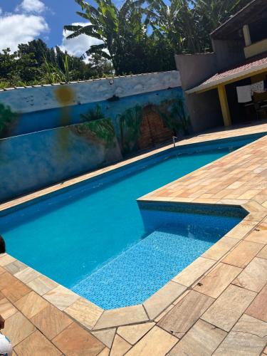 une piscine d'eau bleue et une terrasse en bois dans l'établissement Chácara Rei Davi - Várzea, à Várzea Paulista