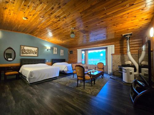 a hotel room with two beds and a fireplace at Alpine Inn in Valemount