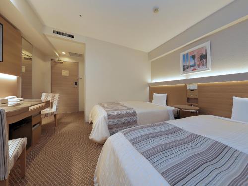 מיטה או מיטות בחדר ב-Keio Presso Inn Otemachi