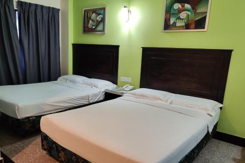 2 camas en una habitación con paredes verdes en Hotel Sri Puchong Sdn Bhd, en Puchong