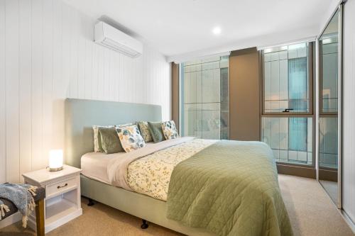 Un dormitorio con una cama grande y una ventana en 2BR Apartment in Geelong w/ Spectacular City View en Geelong