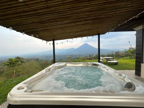 a jacuzzi tub with a view of a mountain at Volcano Views Glampings & Crystal House in Monterrey