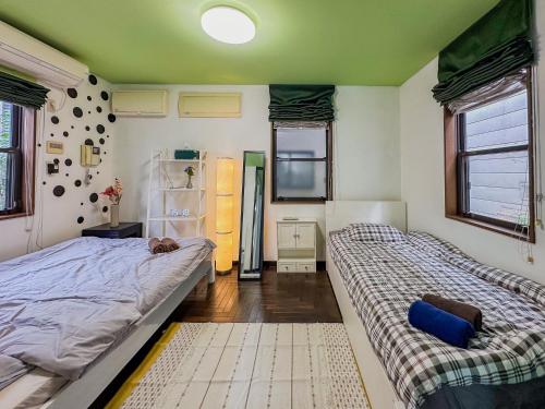 1 Schlafzimmer mit 2 Betten und einem Kühlschrank in der Unterkunft Tranquil Tokyo Retreat #Spacious 3BR House in Hiroo in Tokio