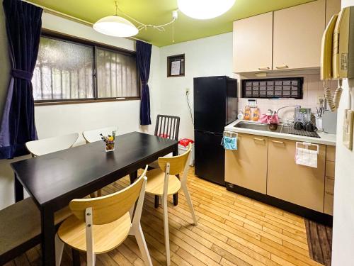 eine Küche und ein Esszimmer mit einem schwarzen Tisch und Stühlen in der Unterkunft Tranquil Tokyo Retreat #Spacious 3BR House in Hiroo in Tokio