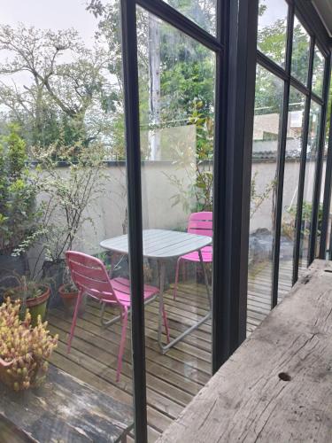 a patio with a table and chairs on a deck at Flambantvieux in Saint-Jean-de-Touslas