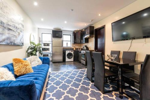 a living room with a blue couch and a table at 3 Bed Modern Apt in Prime Location in New York