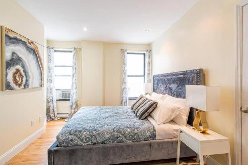 a bedroom with a bed and a table with a lamp at 3 Bed Modern Apt in Prime Location in New York