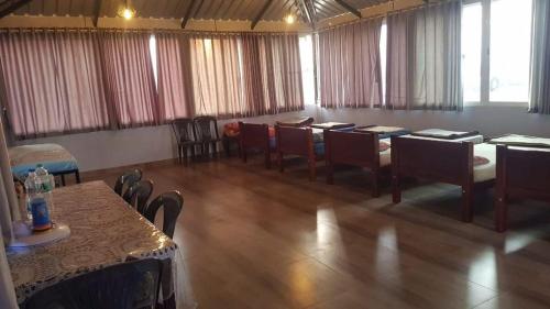 une chambre avec des tables et des chaises dans une chambre avec des fenêtres dans l'établissement Fourseason frankcottage, à Chikmagalur